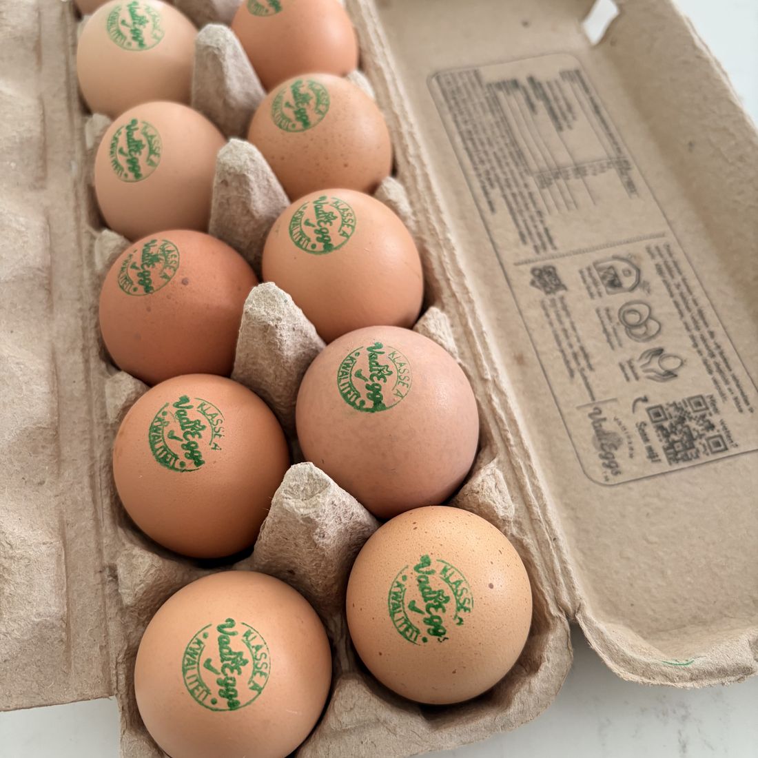 Open VadiEggs doosje met gestempelde eieren en informatie aan de binnenkant